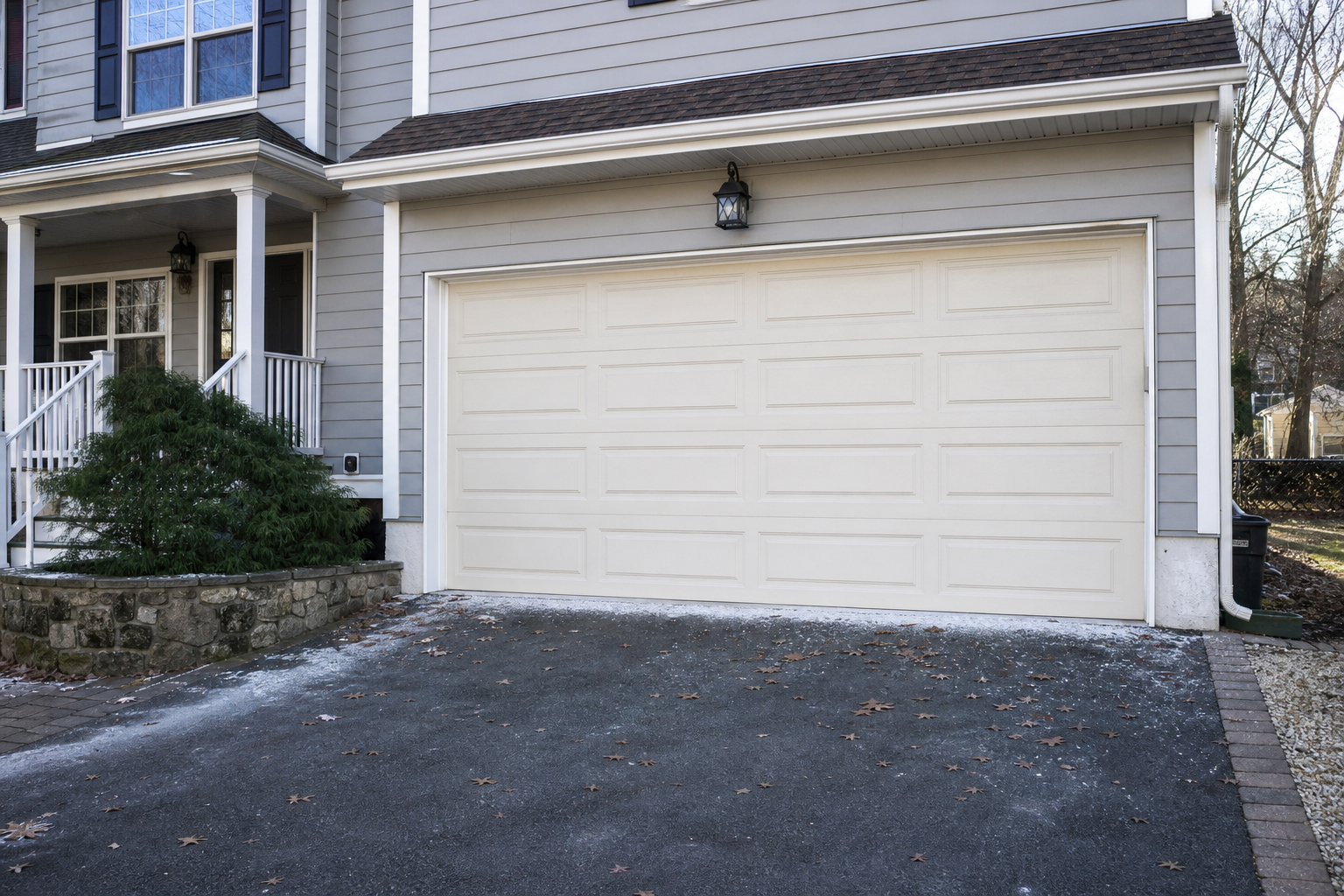 Suburban Maplewood home with a closed garage door and seasonal wear near the base